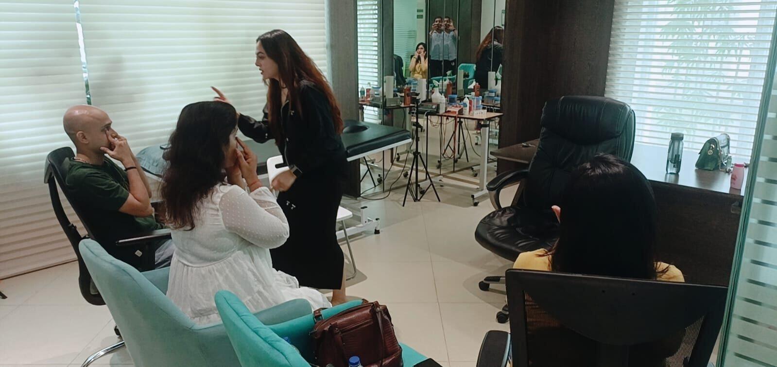 Vibha Jain speaking with a small group of seated clients in a bright consulting room.
